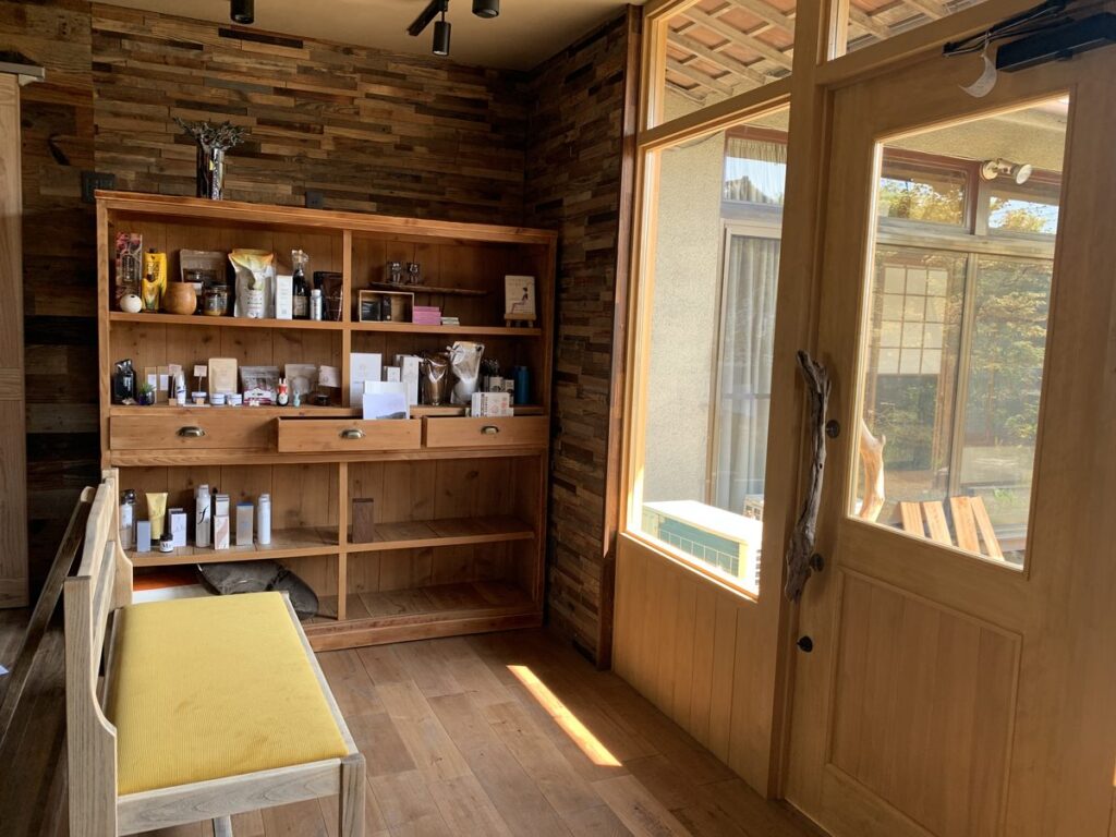 Wooden shelving unit filled with skincare and beauty products in a warmly lit room with wooden walls.